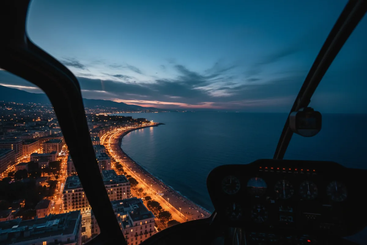 Vue aérienne de la baie de Cannes et de la Croisette illuminées la nuit depuis un hélicoptère.