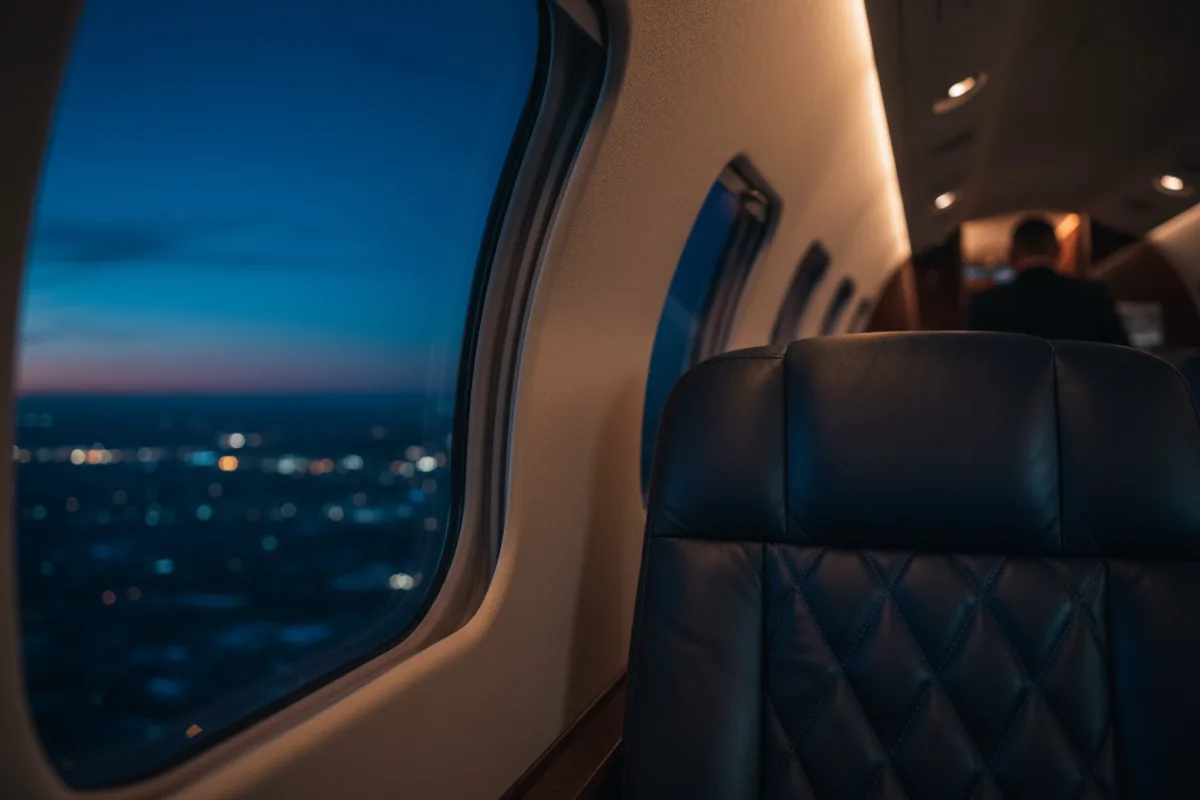 Close-up of a luxurious, empty quilted leather seat inside a private jet cabin.