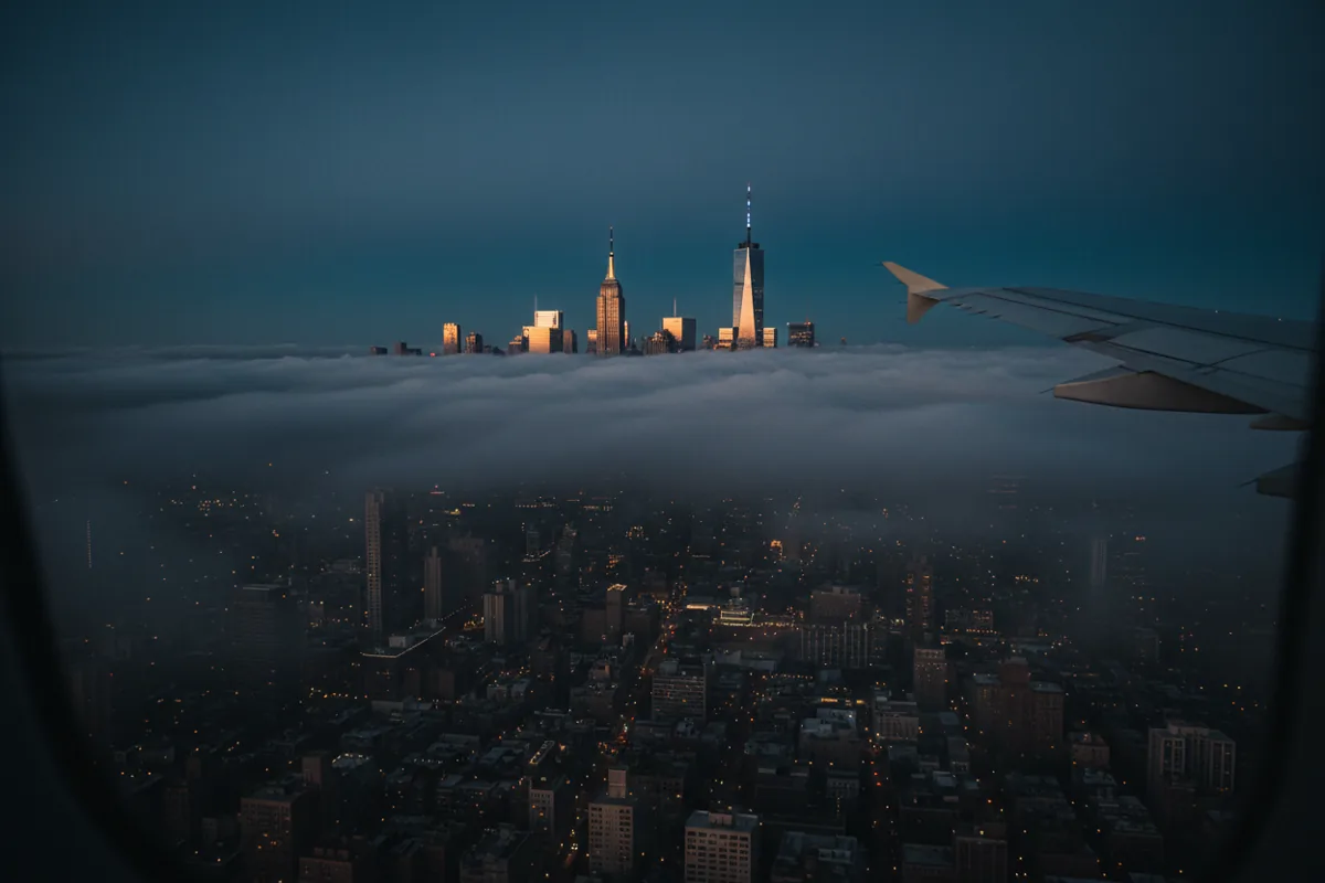 The New York City skyline seen from above the clouds at dawn.
