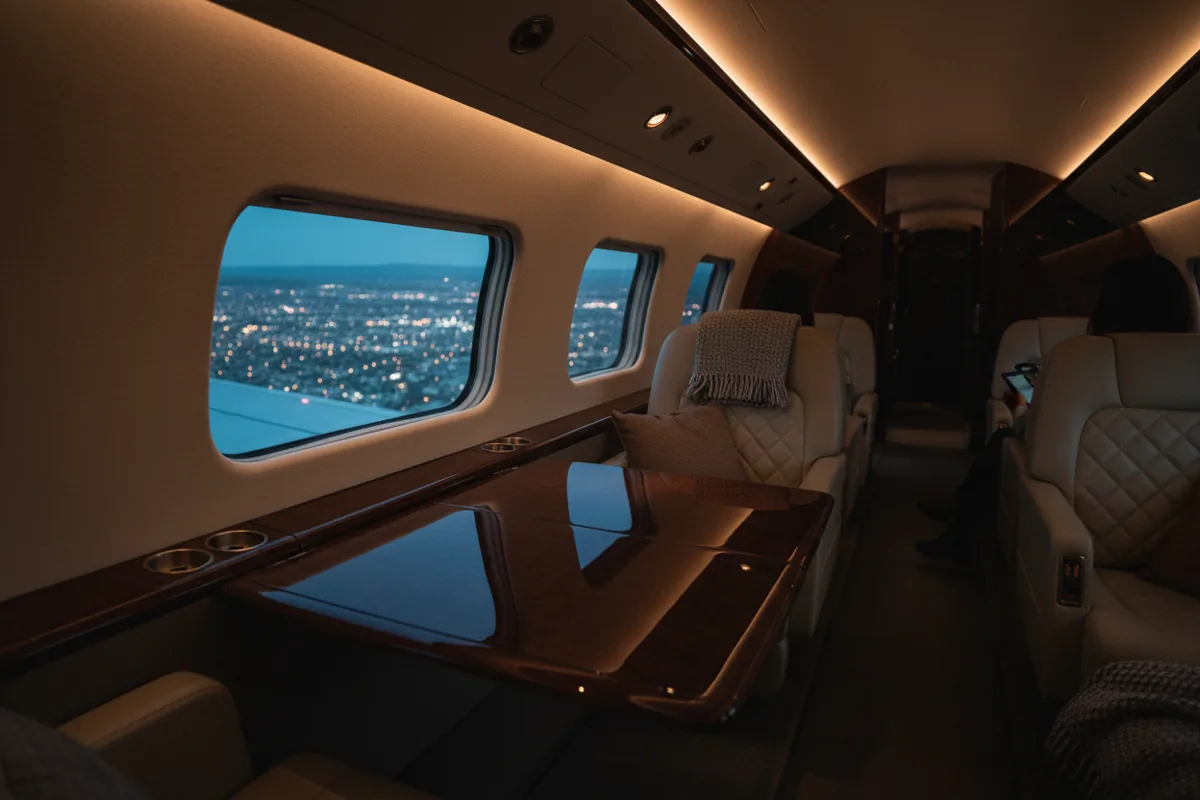 The luxurious interior of a private jet cabin with leather seats, seen at night.