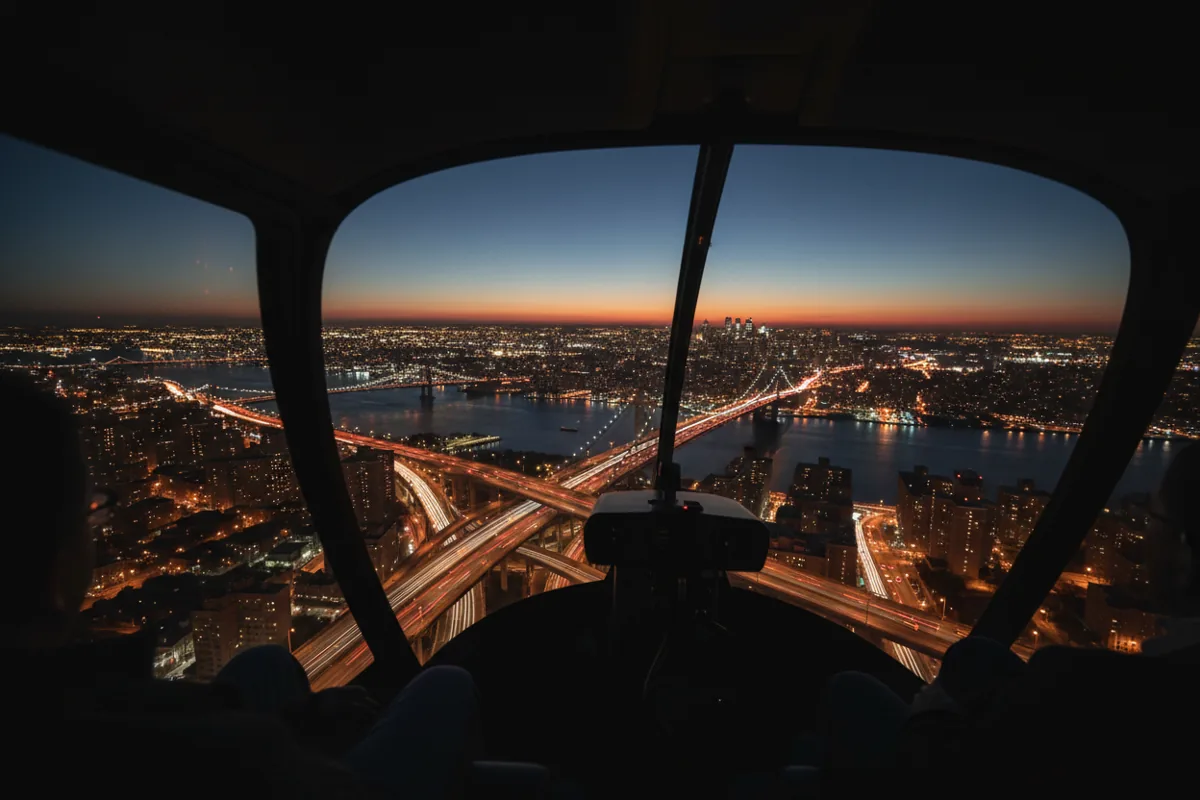 View of New York City's bridges and lights at night from inside a helicopter.