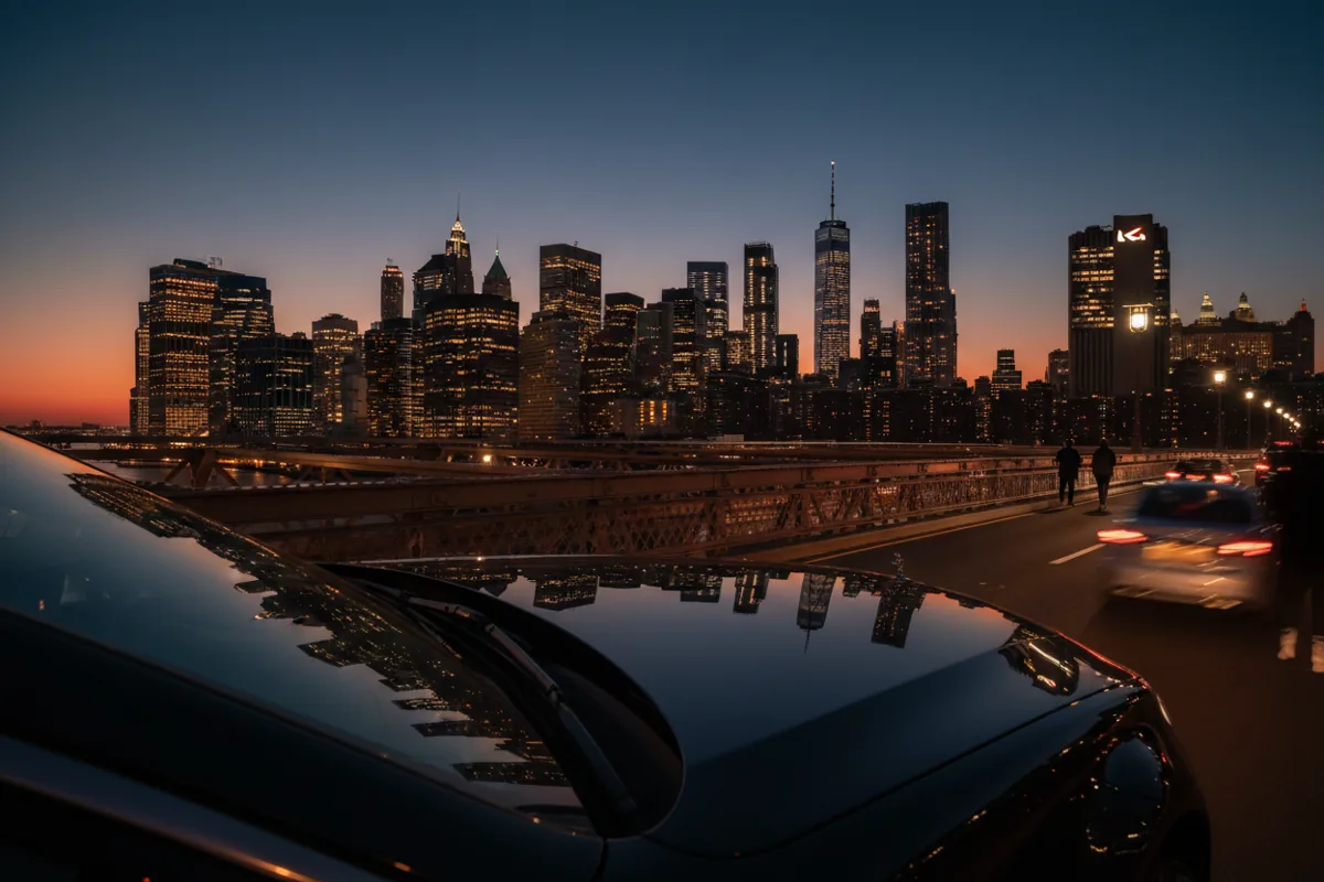 The New York City skyline seen from a car on a highway at dusk.