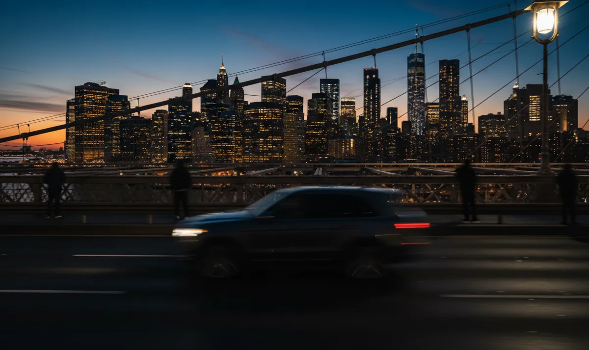 A luxury SUV in motion, crossing a bridge towards a brightly lit city skyline at night.