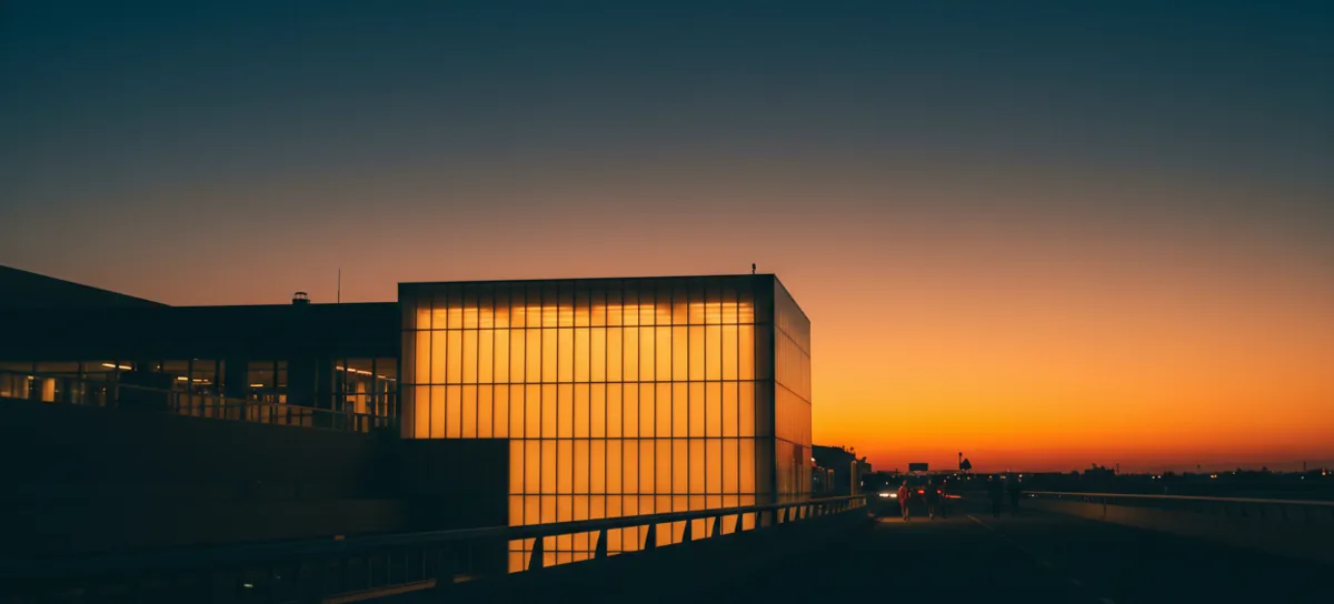 An illuminated sign for Newark Liberty International Airport at dusk.