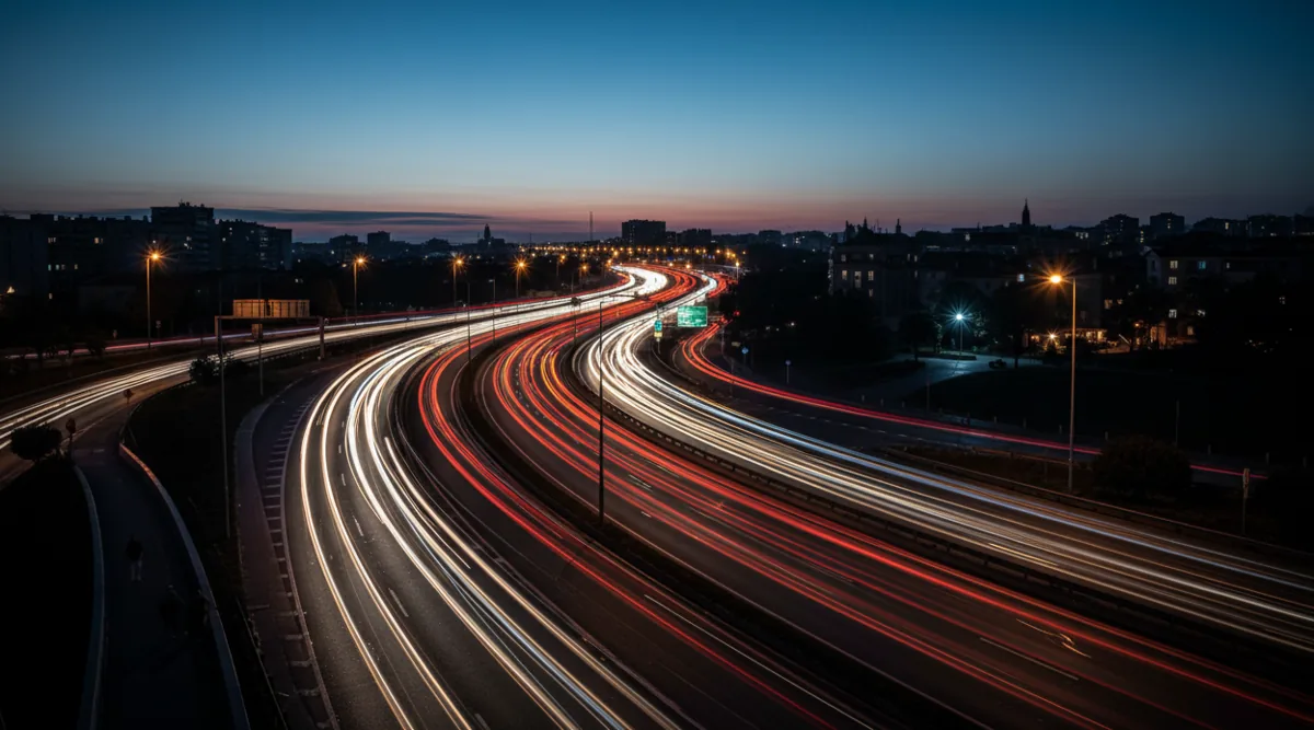 Long-exposure photograph showing streaks of light from traffic on a highway at night.